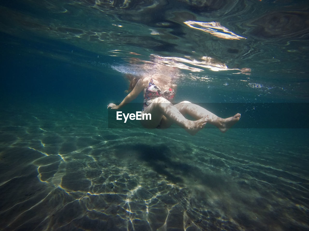 Woman swimming underwater in sea