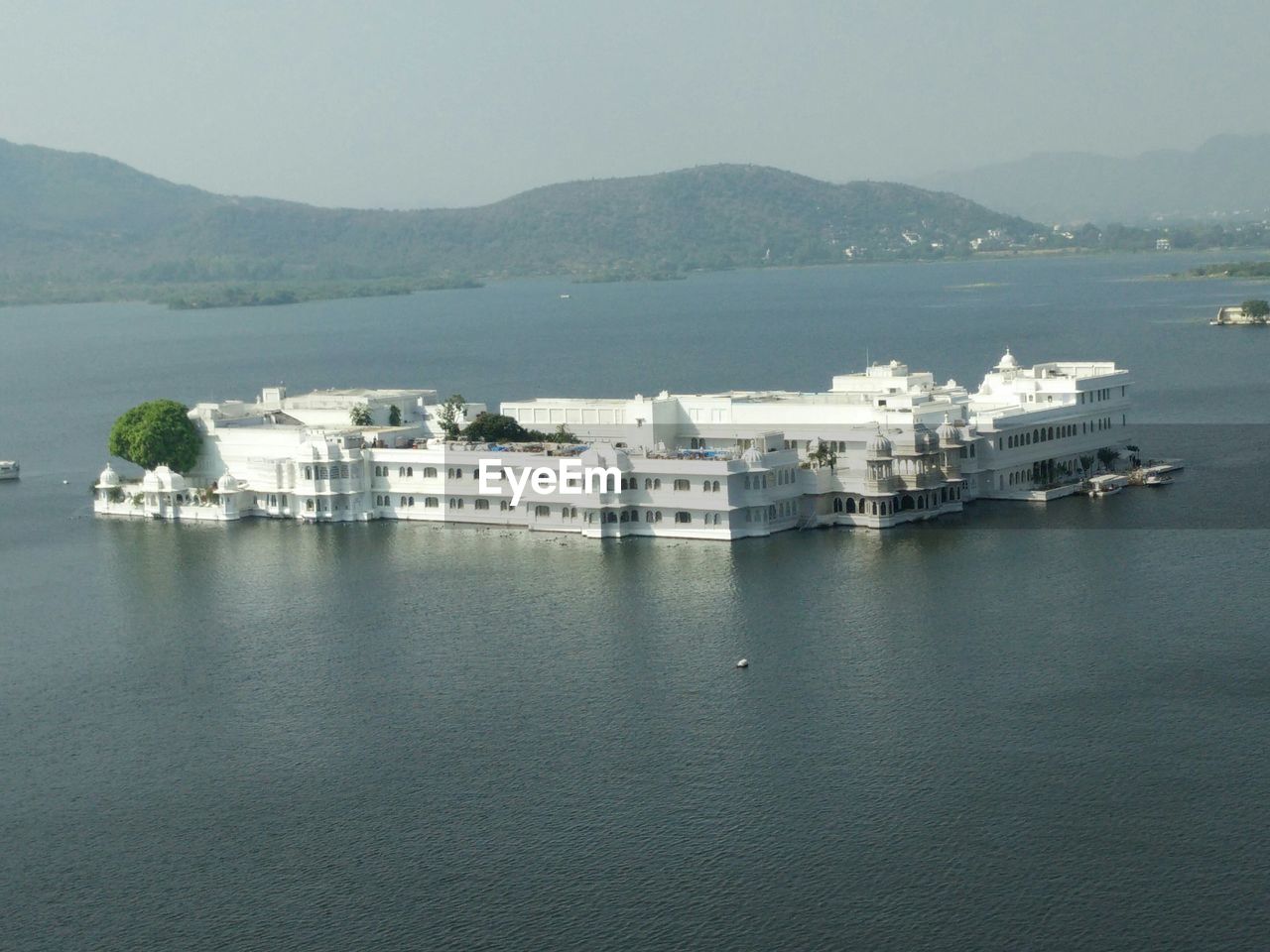 BOATS IN SEA WITH TOWN IN BACKGROUND