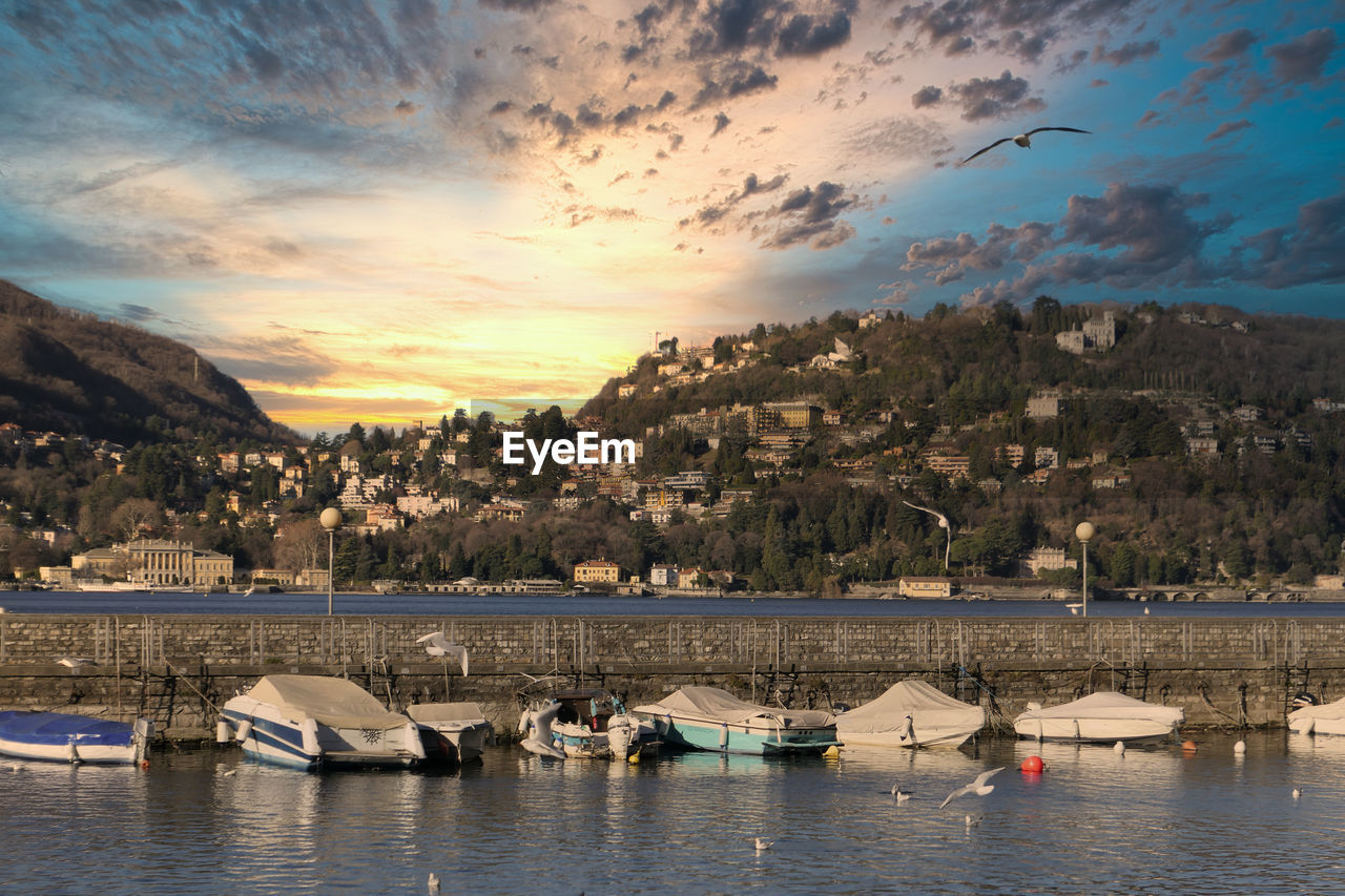 BOATS MOORED IN BAY AGAINST CITYSCAPE