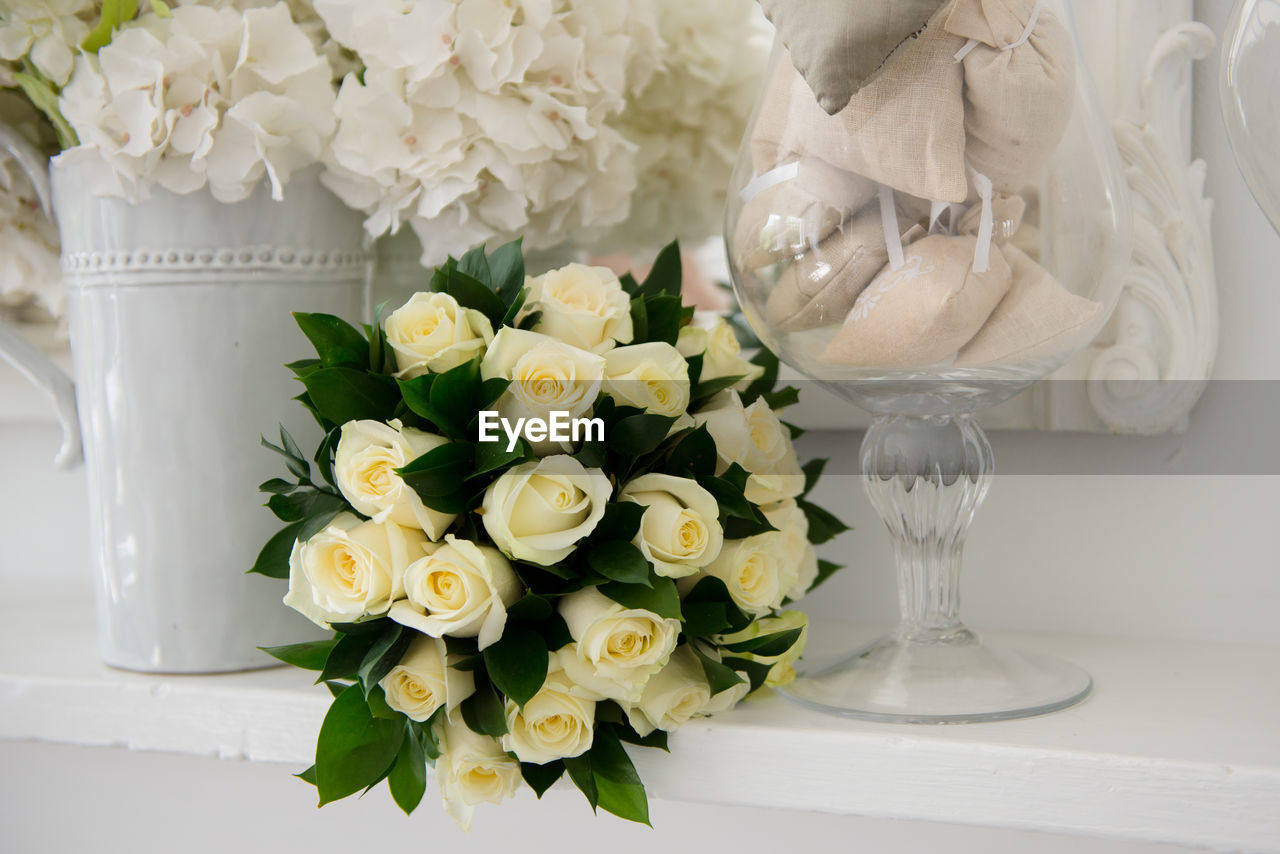 CLOSE-UP OF ROSES IN VASE ON TABLE