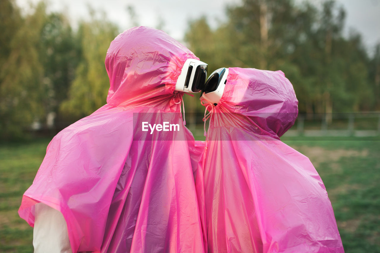 Couple wearing virtual reality simulator on grassy field