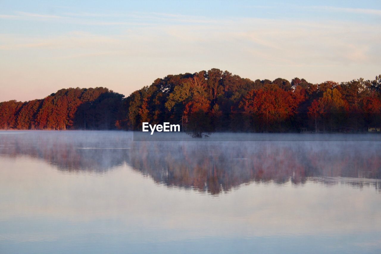 Scenic view of lake by trees against sky during autumn