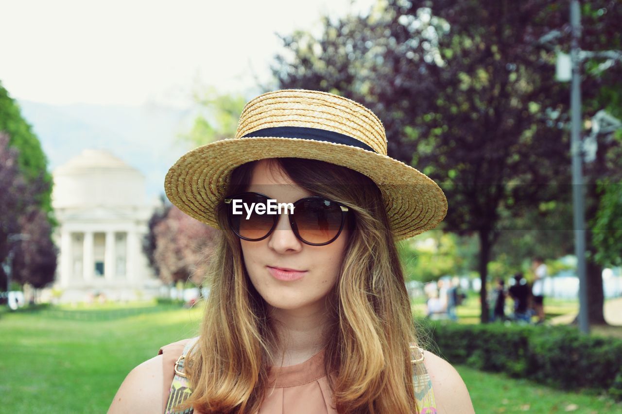 PORTRAIT OF YOUNG WOMAN WEARING SUNGLASSES