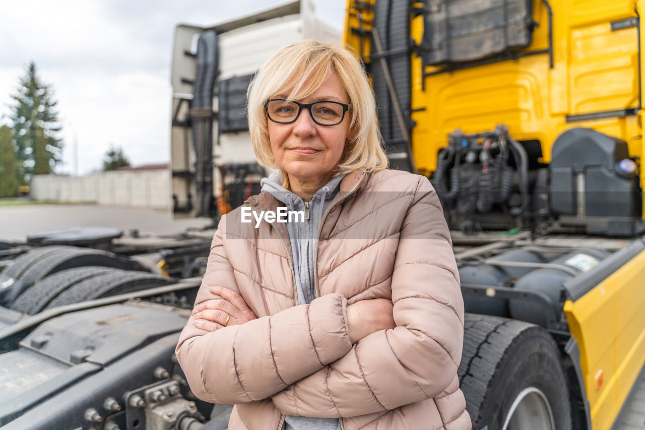 Portrait of woman standing against truck