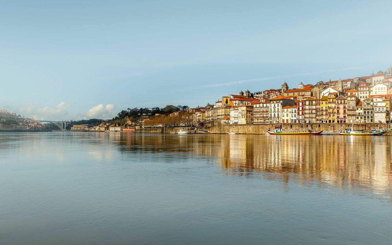 View of houses by river against clear sky