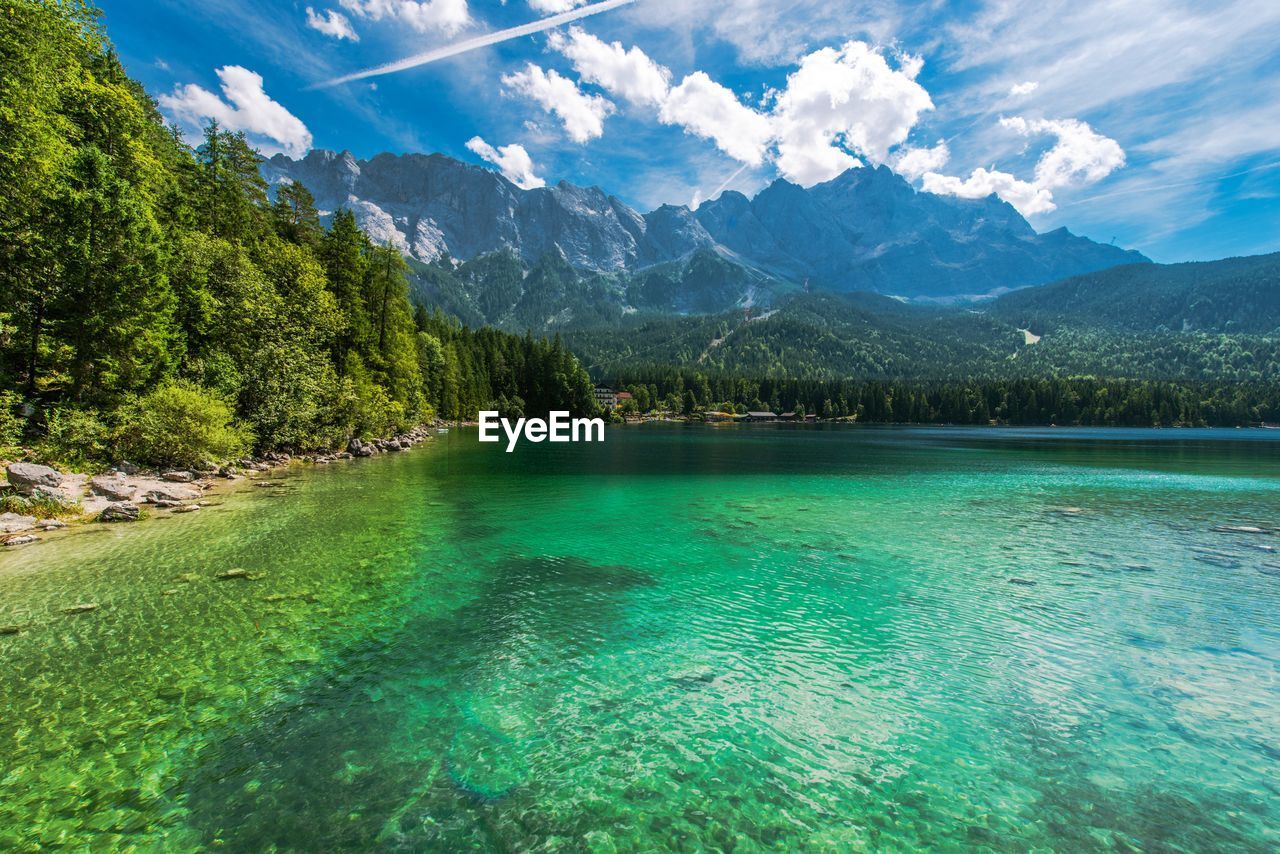 Scenic view of lake by mountains against sky