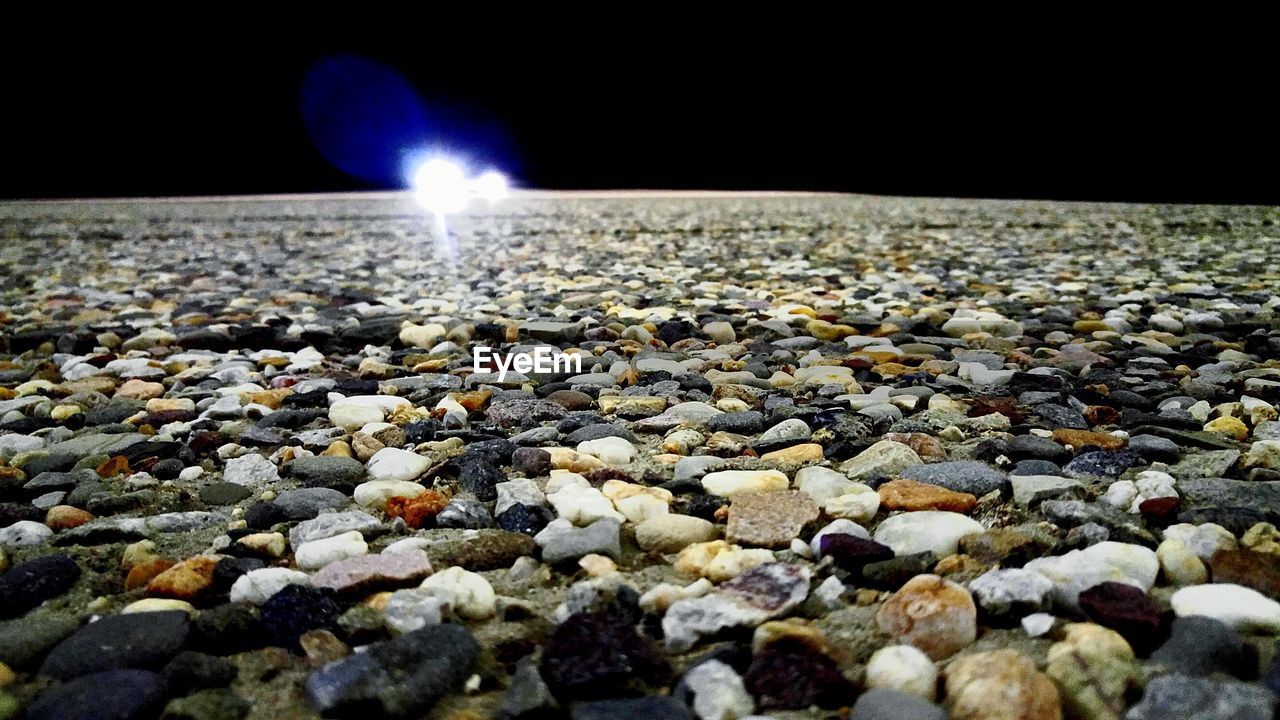 Surface level of pebbles against clear sky