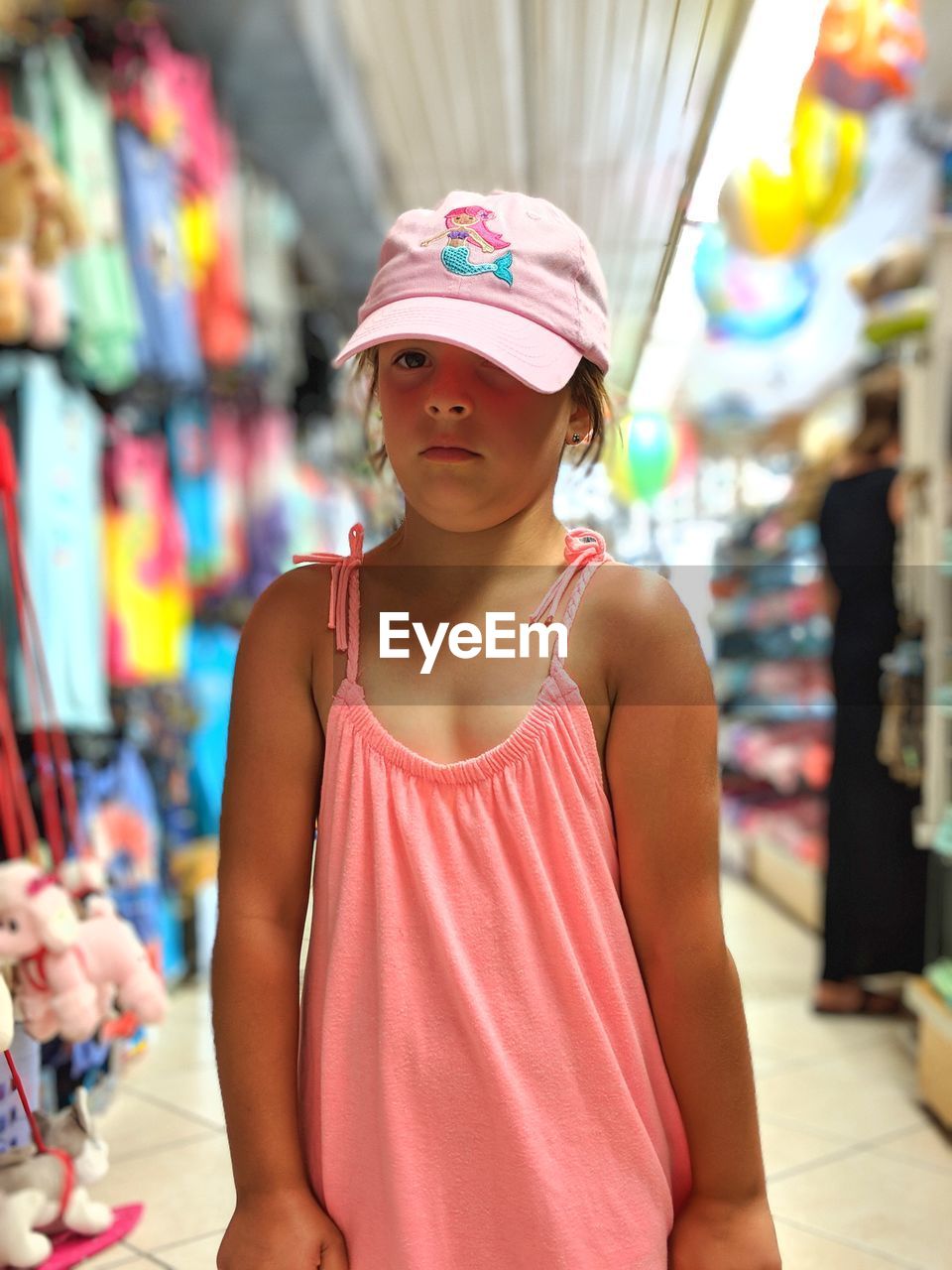 Portrait of cute girl wearing cap while standing at store