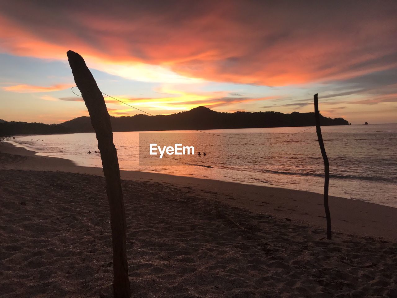 SCENIC VIEW OF BEACH AGAINST ORANGE SKY