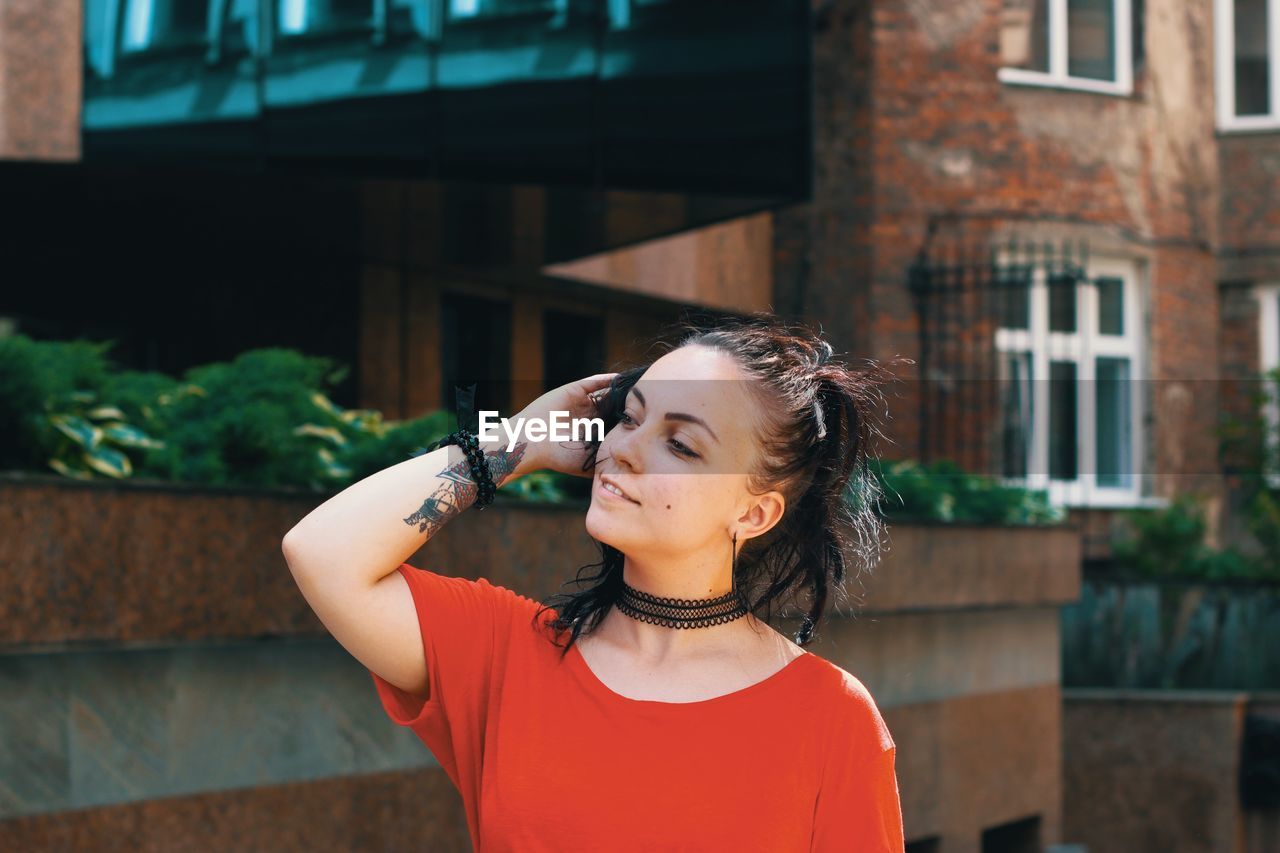 Beautiful young woman looking away in city