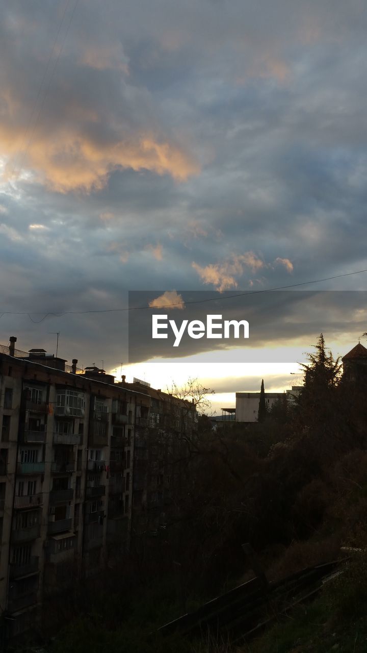 HOUSES AGAINST SKY AT SUNSET