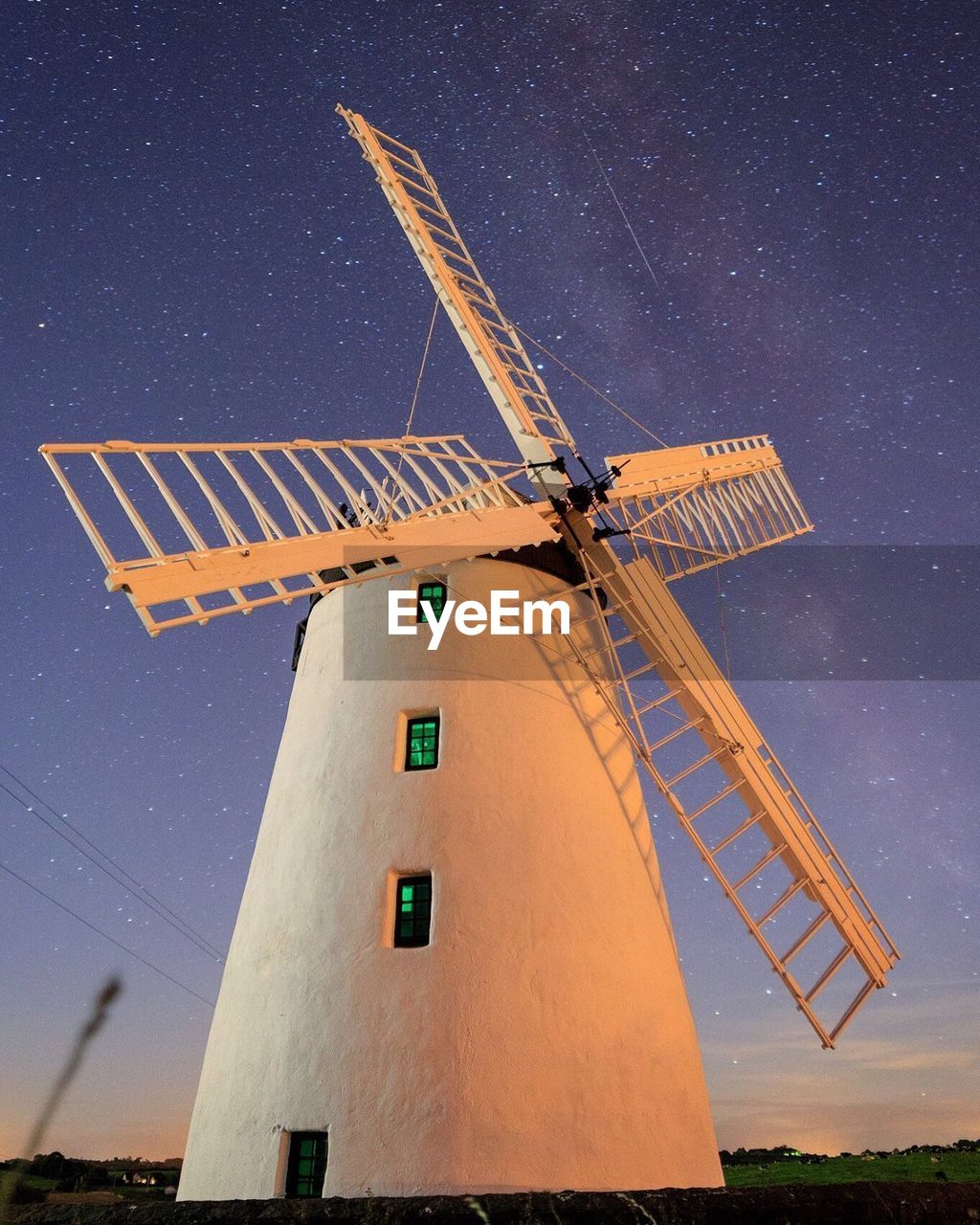 Low angle view of windmill against sky at night