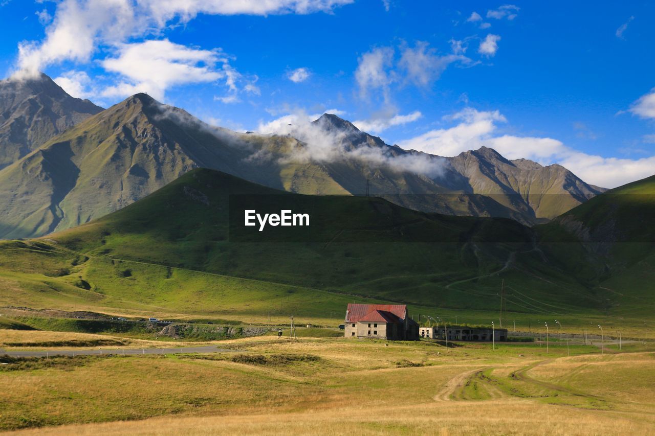 Scenic view of field and mountains against sky