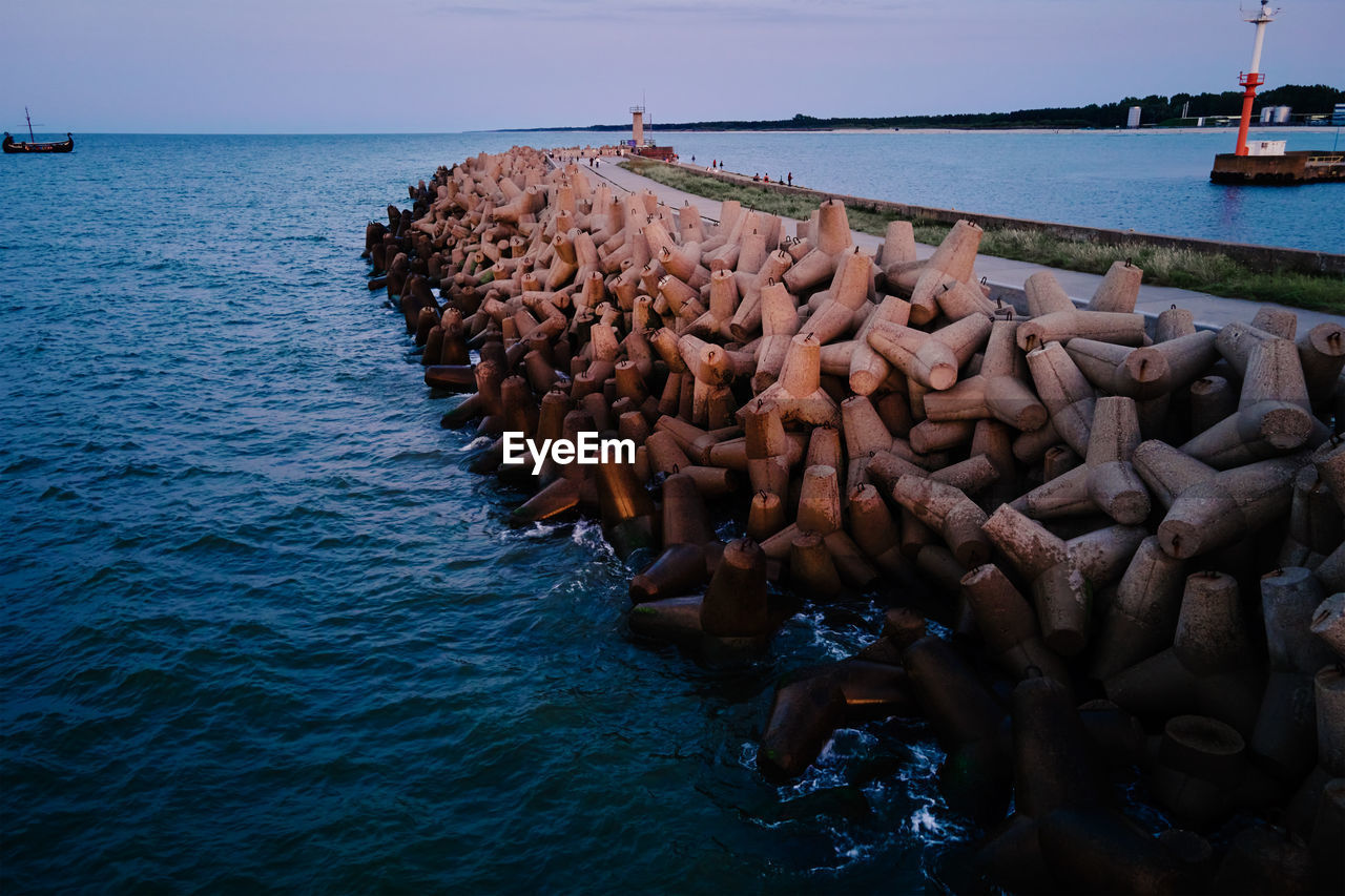 Waves break on concrete tetrapod breakwaters at sea coast. protection from large waves