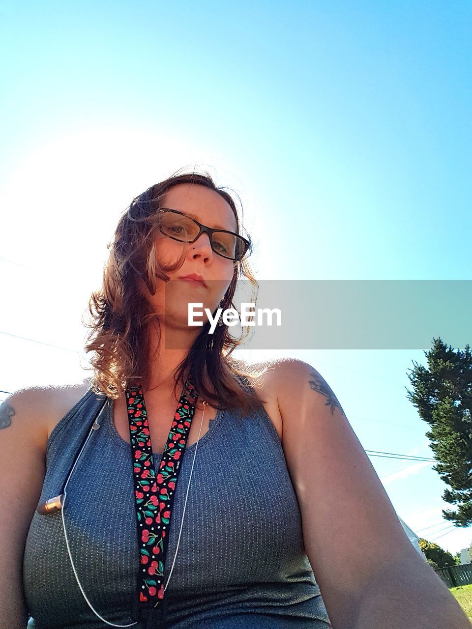 PORTRAIT OF WOMAN STANDING AGAINST THE SKY