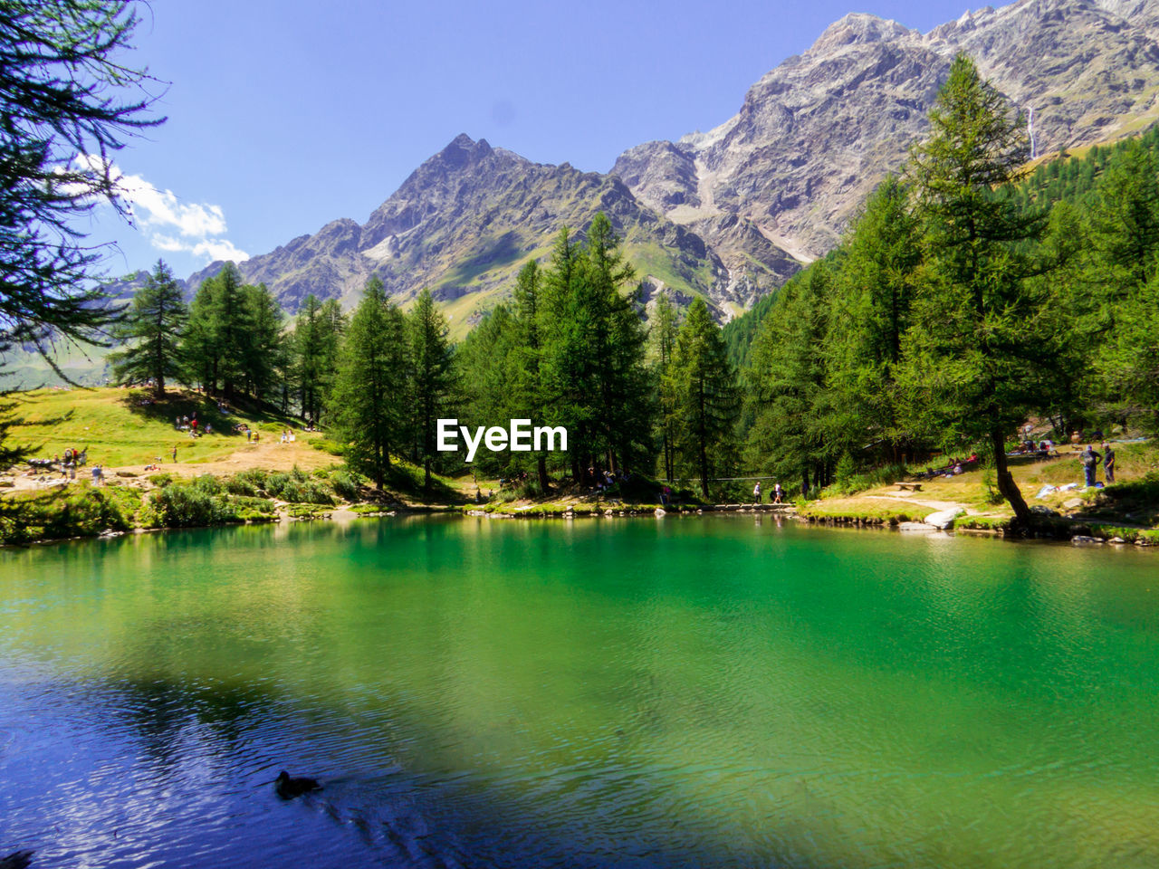 scenic view of lake by mountains against sky