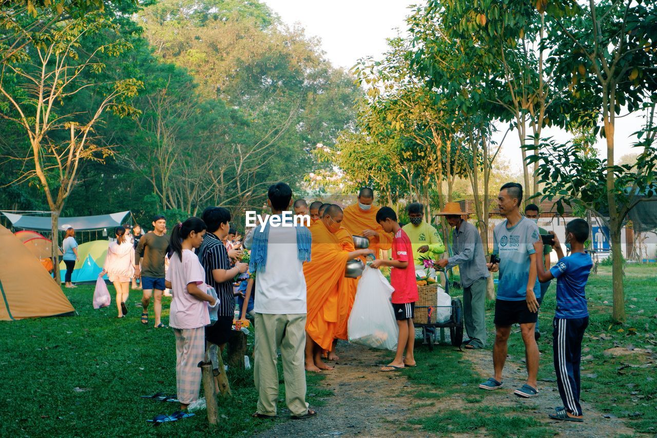 GROUP OF PEOPLE STANDING BY TREE