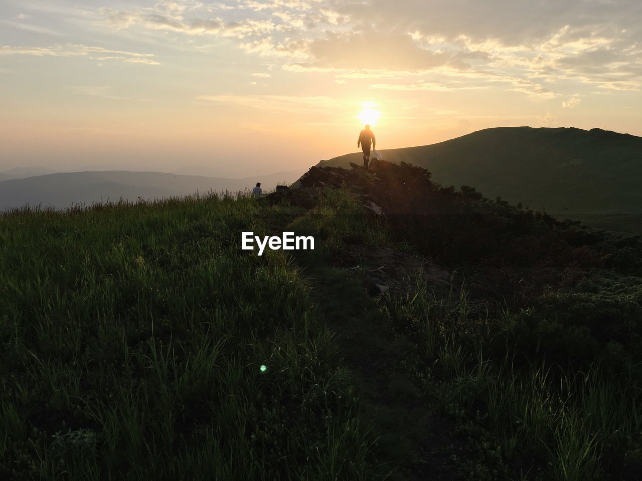 Silhouette man hiking on mountain against sky during sunset