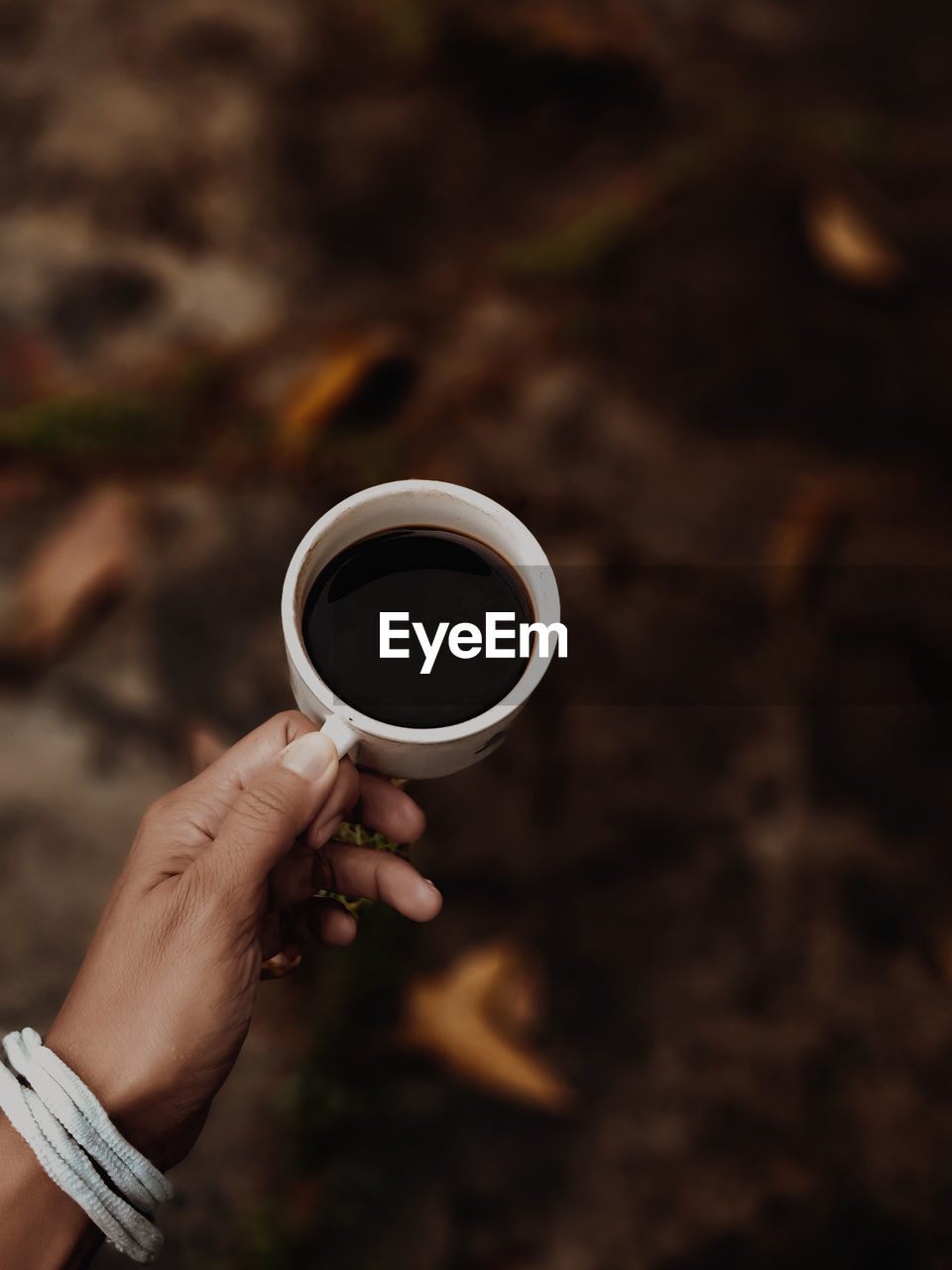 Cropped hand holding coffee cup