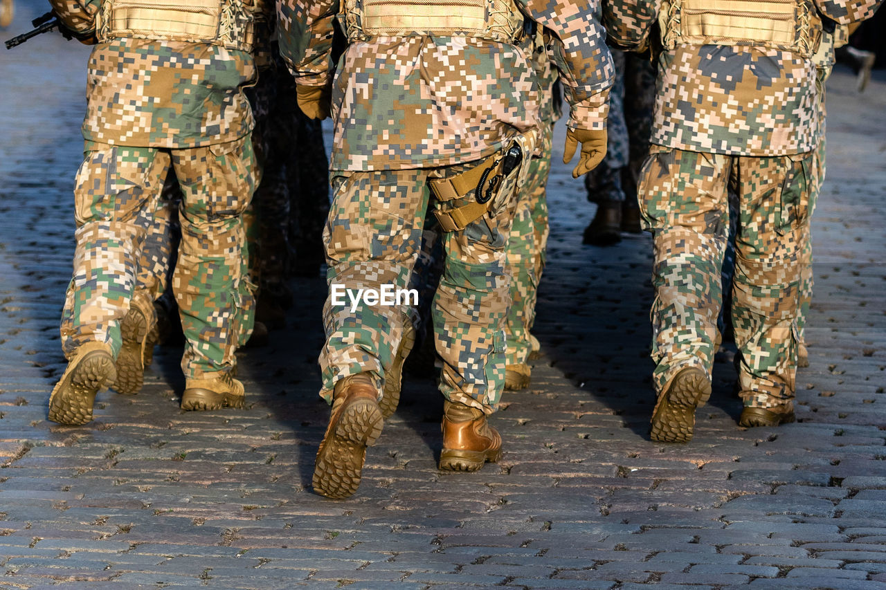 Low section of soldiers walking in parade on footpath