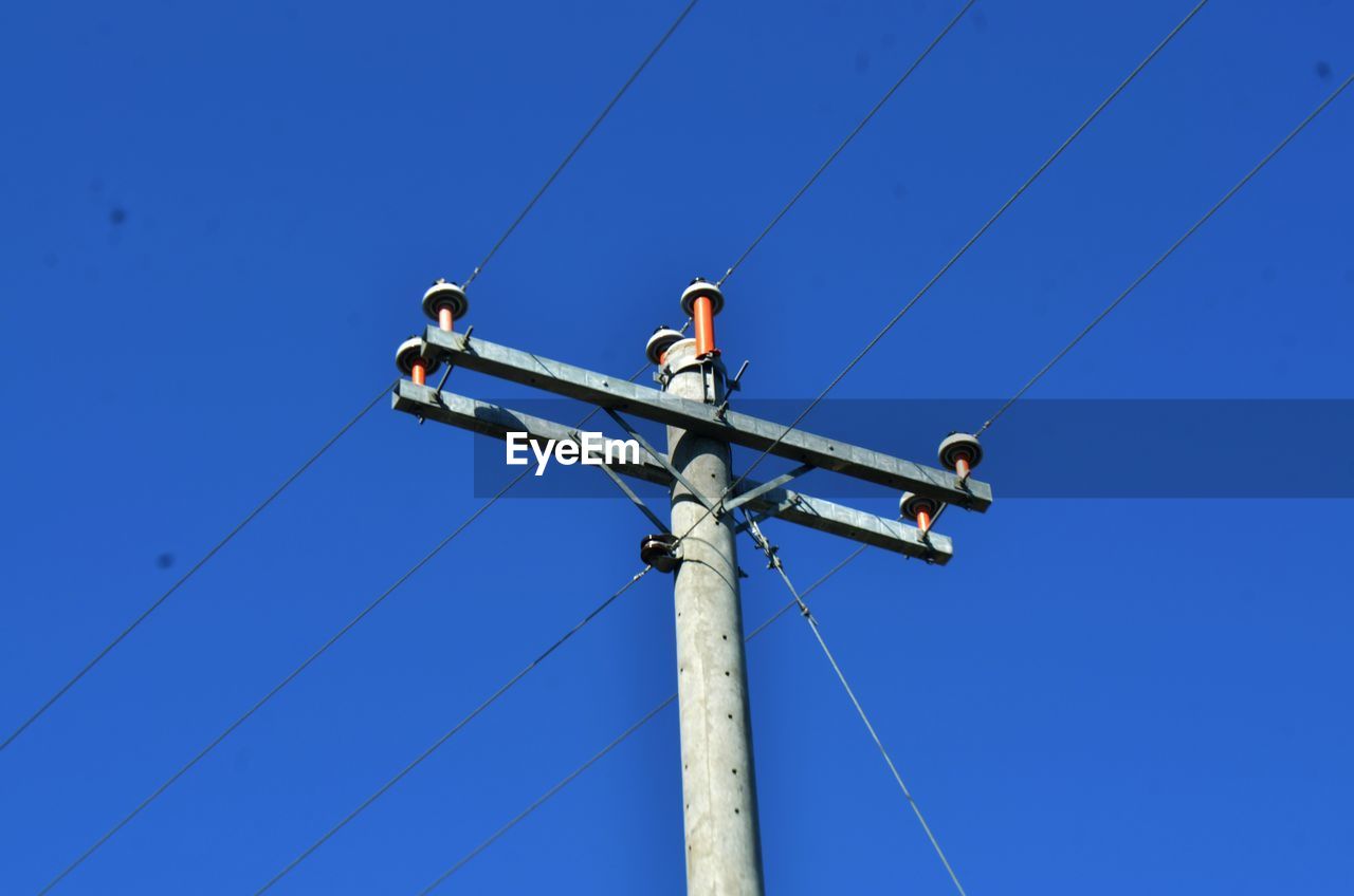 Low angle view of telephone line against clear blue sky