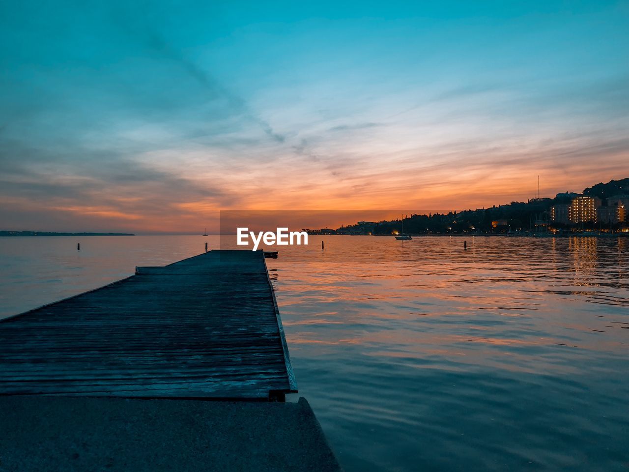 PIER OVER SEA AGAINST SKY AT SUNSET