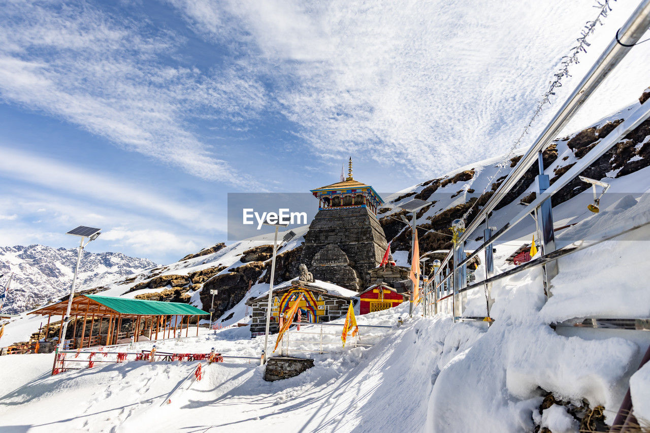 Isolated ancient holy hindu temple in himalayan mountain range with bright blue sky