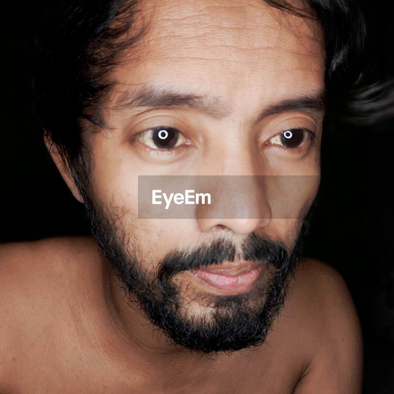 Close-up portrait of shirtless young man