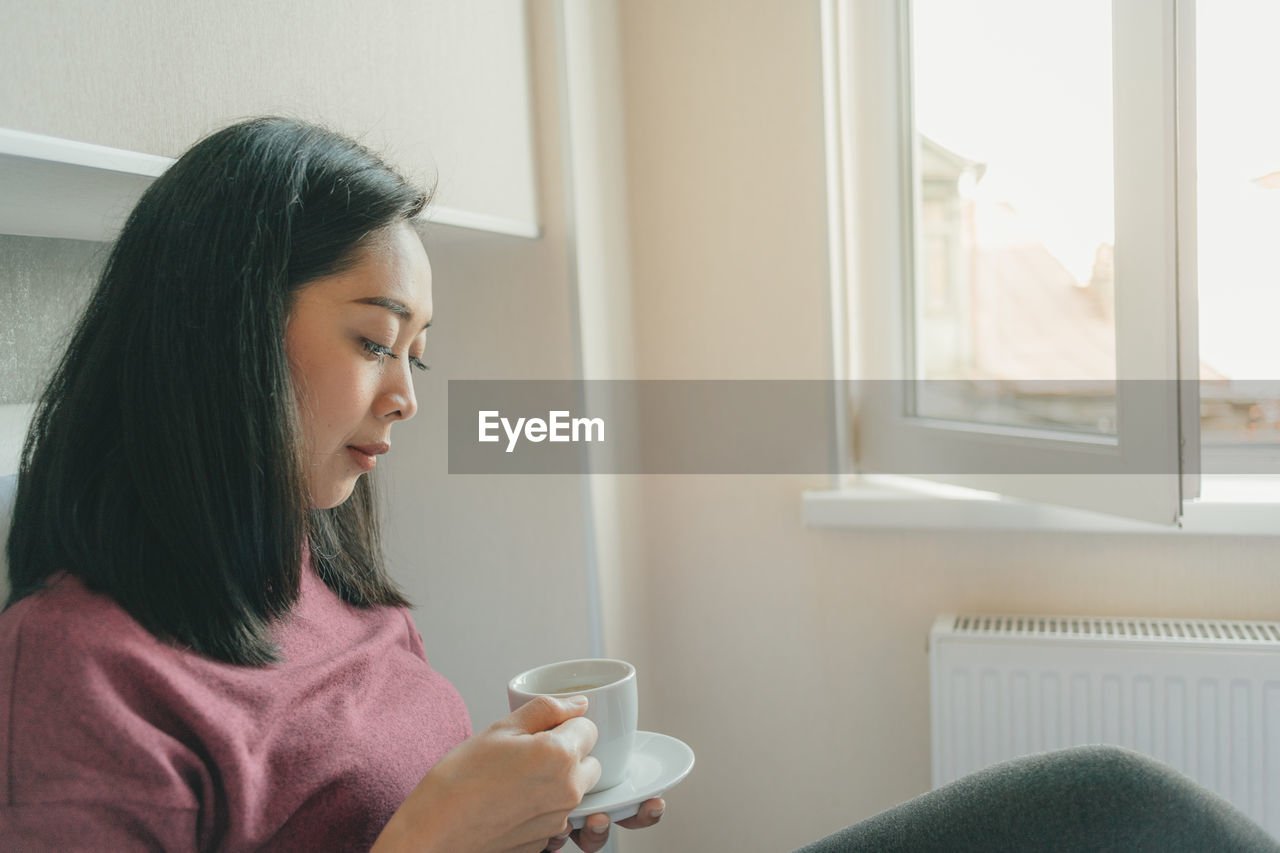 Woman having coffee at home