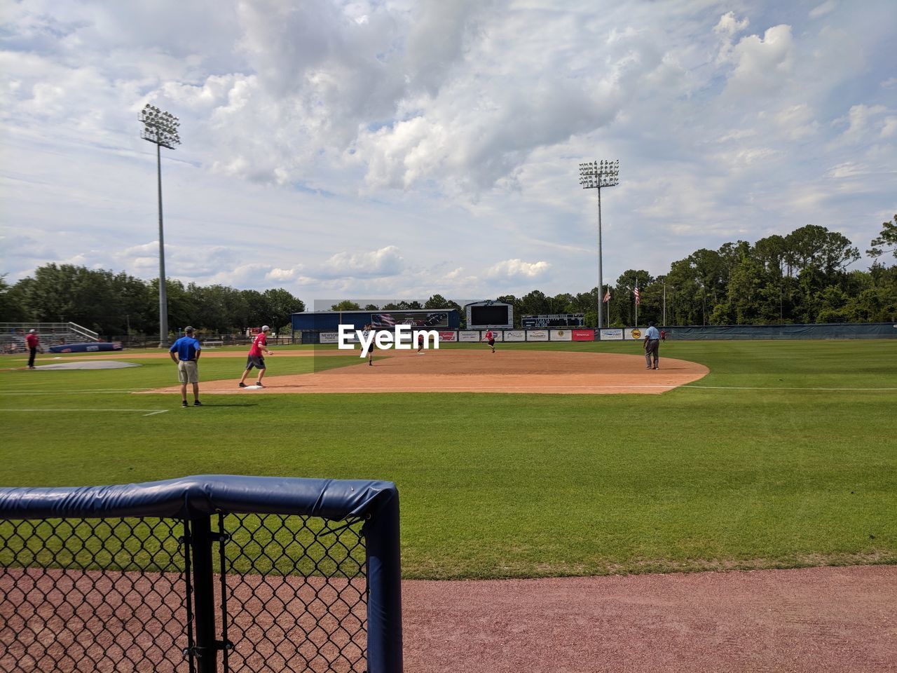 GROUP OF PEOPLE PLAYING FIELD AGAINST SKY