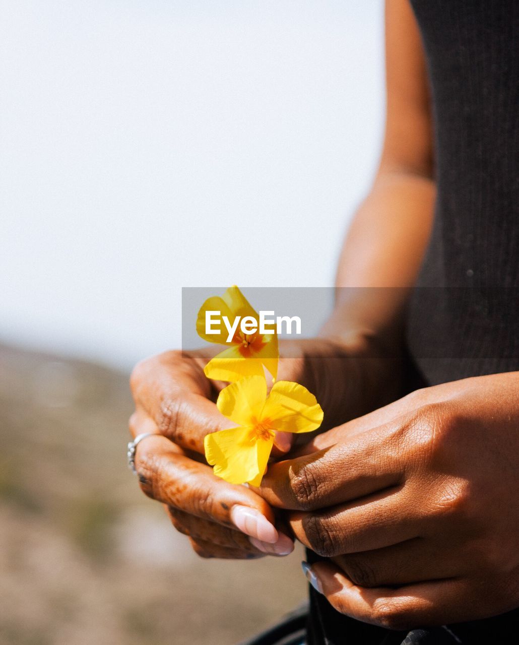 Close-up of woman holding flowers against blurred background