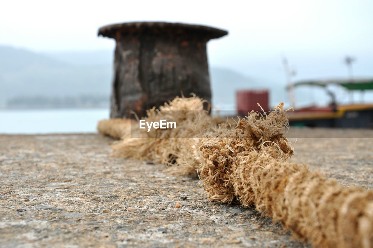 Rope tied on bollard at harbor