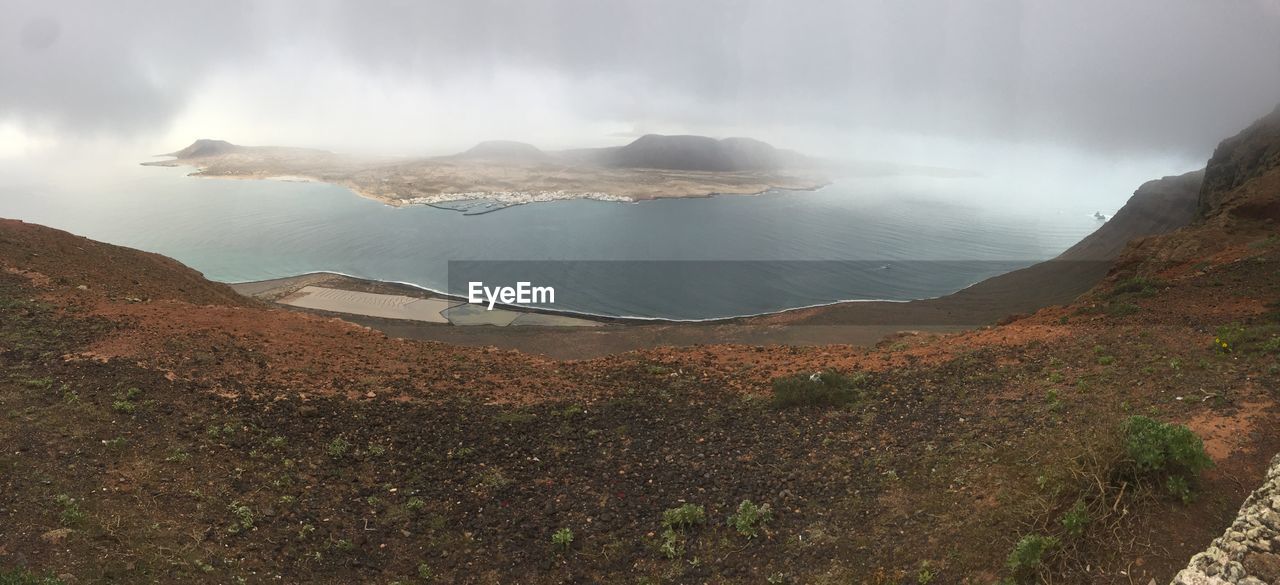 Scenic view of sea and mountains against sky