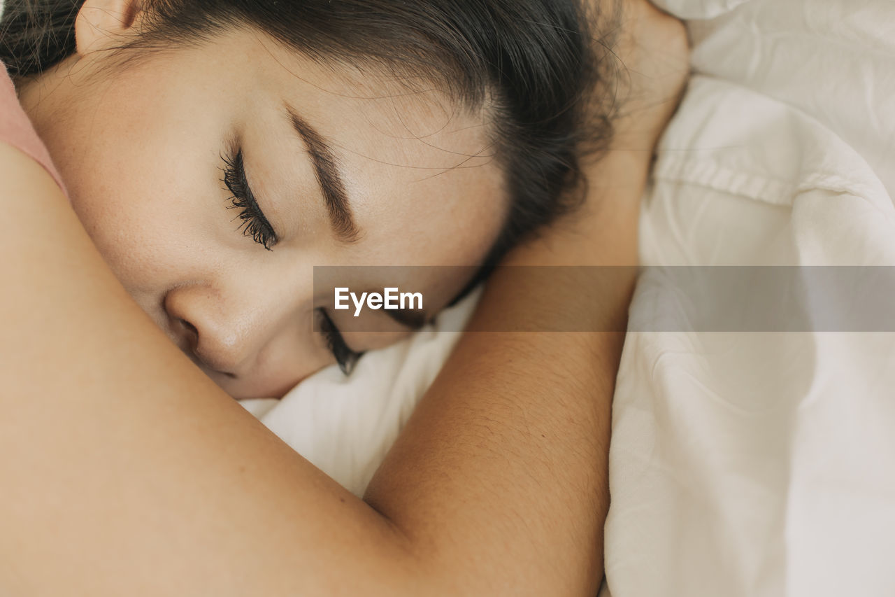 High angle view of woman sleeping on bed