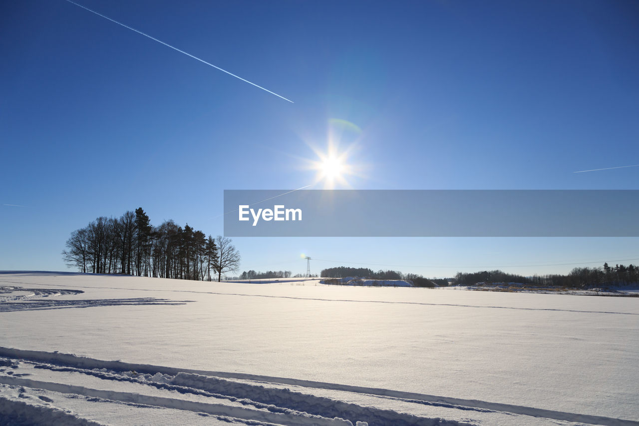 Scenic view of vapor trail against clear blue sky during winter