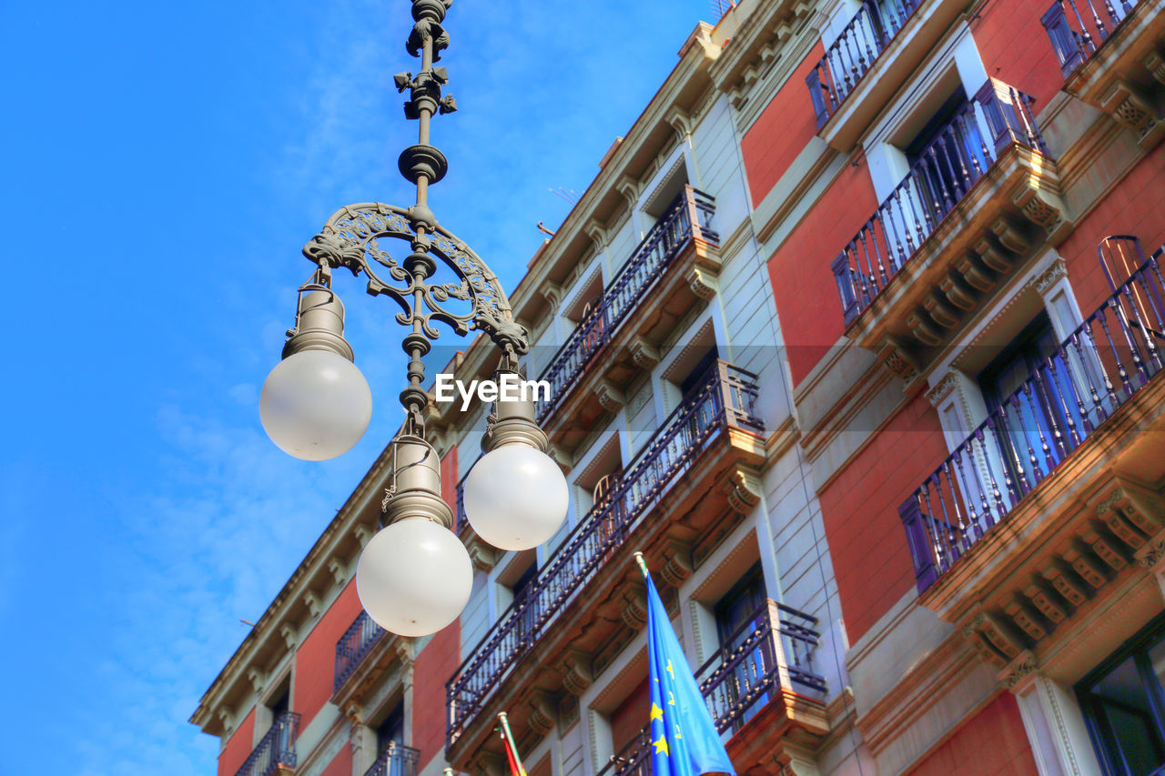 LOW ANGLE VIEW OF STREET LIGHT HANGING ON BUILDING