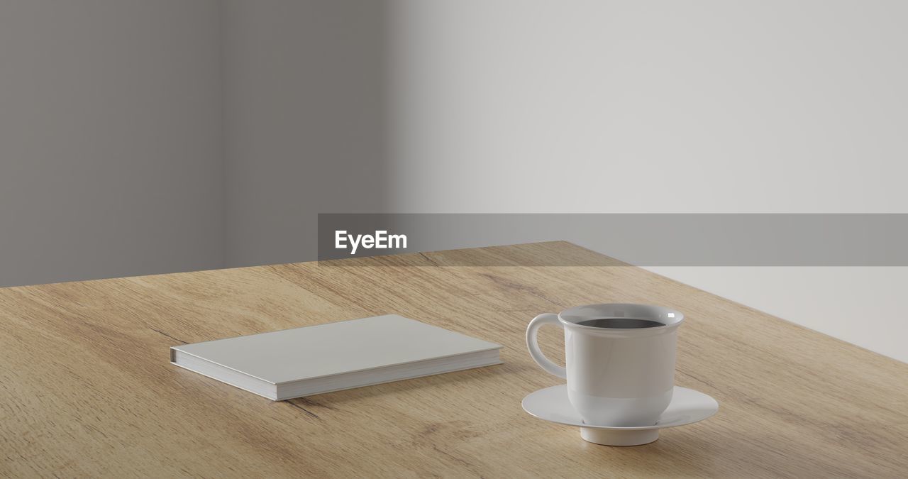 CLOSE-UP OF COFFEE CUP ON TABLE AGAINST WALL