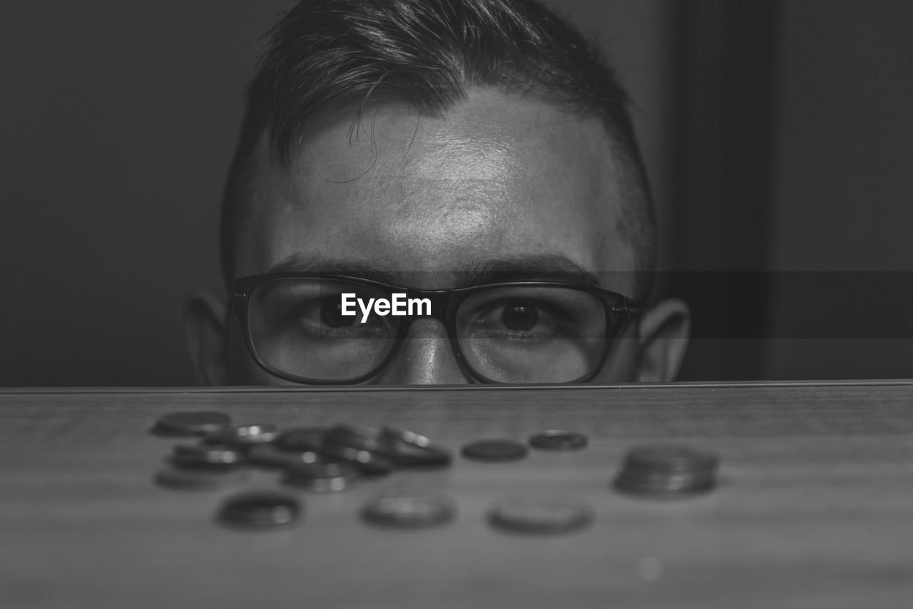 Cropped image of man by coins at table