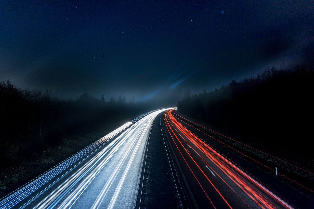 night, long exposure, motion, light trail, transportation, speed, illuminated, road, sky, blurred motion, highway, darkness, traffic, city, tail light, the way forward, nature, street, star, light, architecture, no people, travel, headlight, light - natural phenomenon, landscape, mode of transportation, space, scenics - nature, vanishing point, dark, infrastructure, outdoors, on the move, lighting equipment, environment, travel destinations, glowing, red, journey, beauty in nature, astronomy, motor vehicle, multiple lane highway