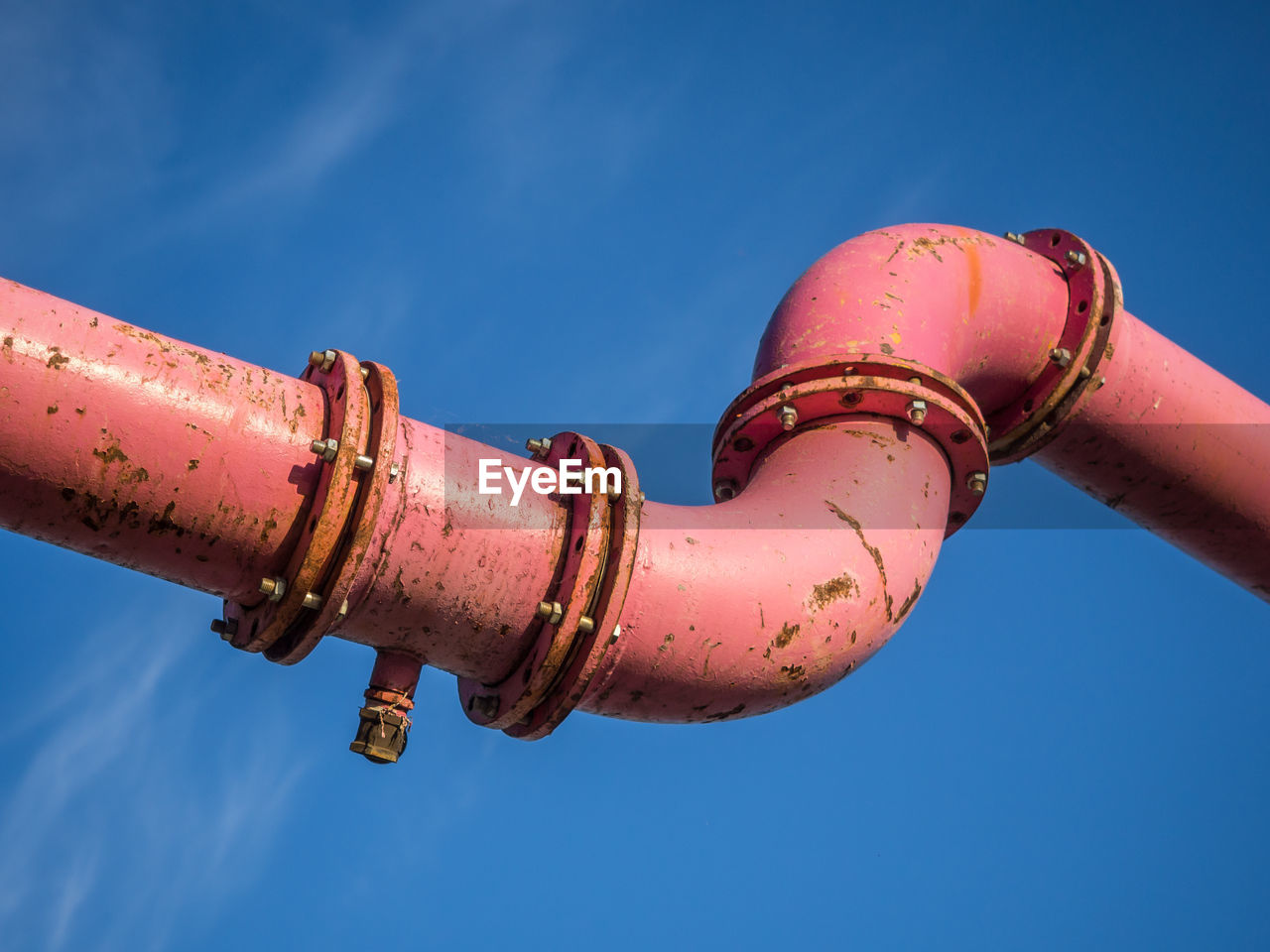 Low angle view of pink pipe against blue sky