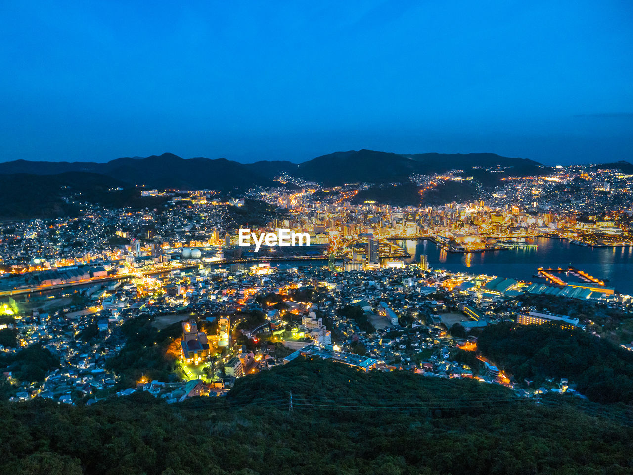 HIGH ANGLE VIEW OF ILLUMINATED CITY AT NIGHT