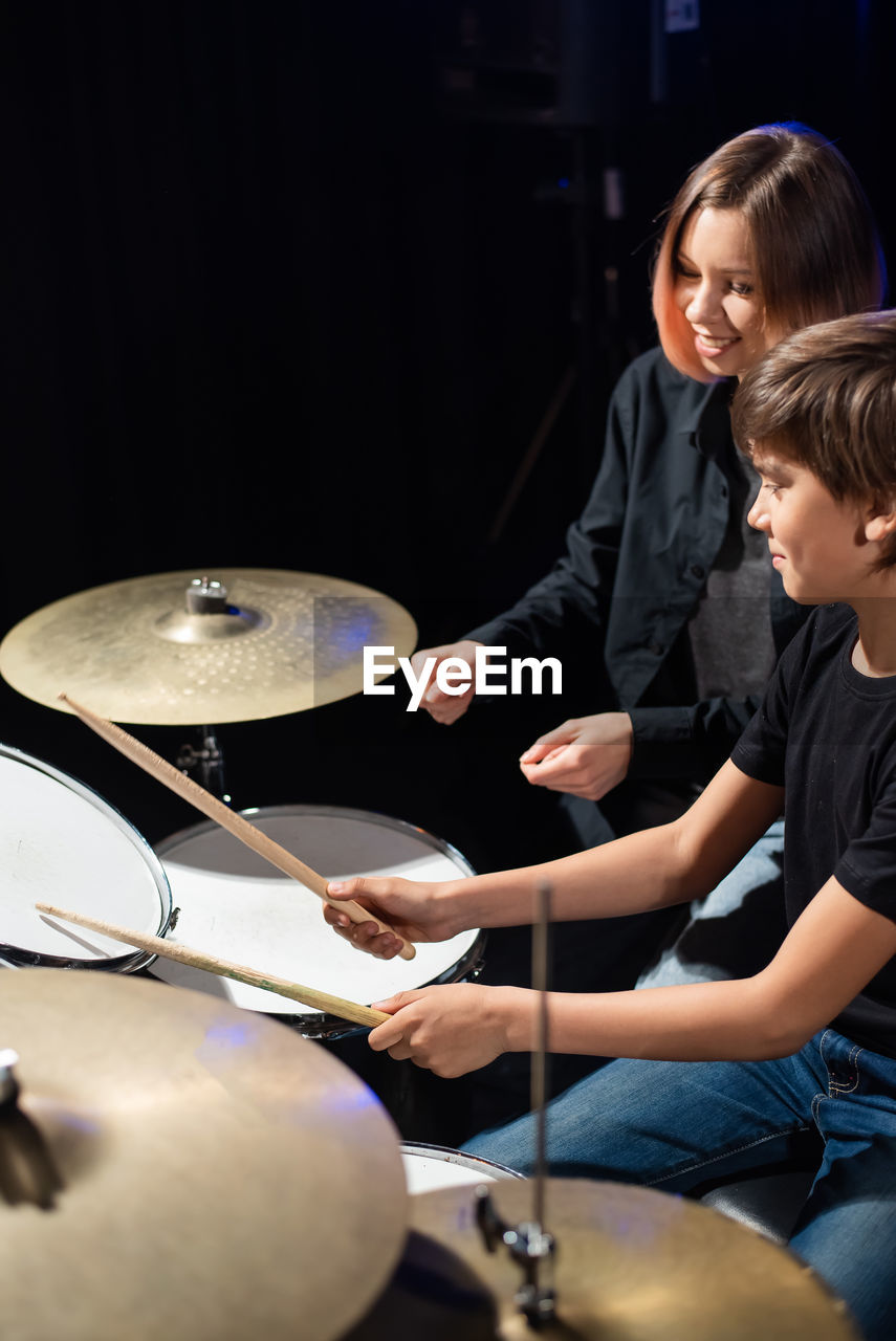 side view of man playing drum