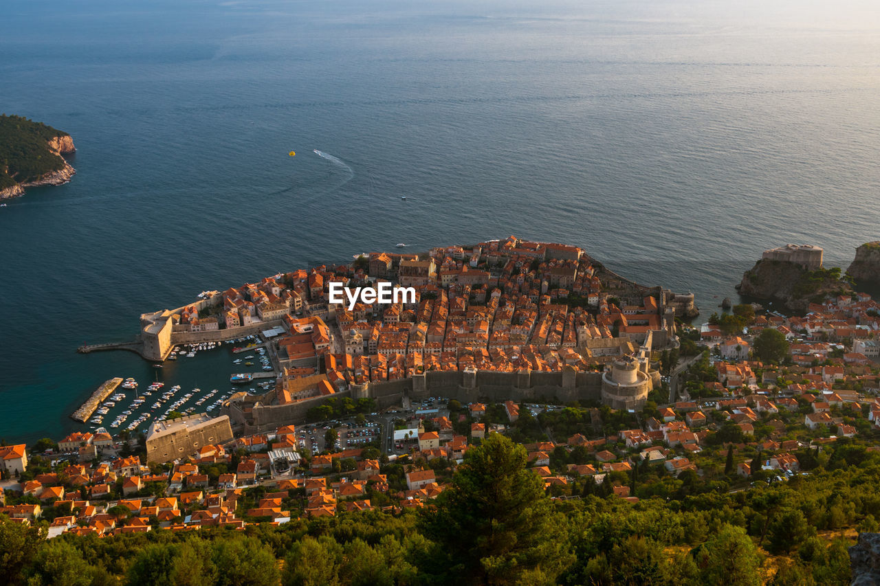 High angle view of cityscape by sea against sky