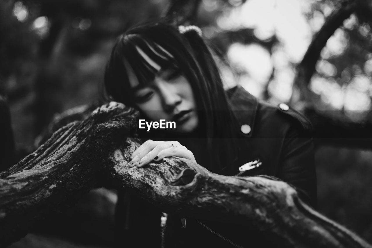 Woman leaning on branch