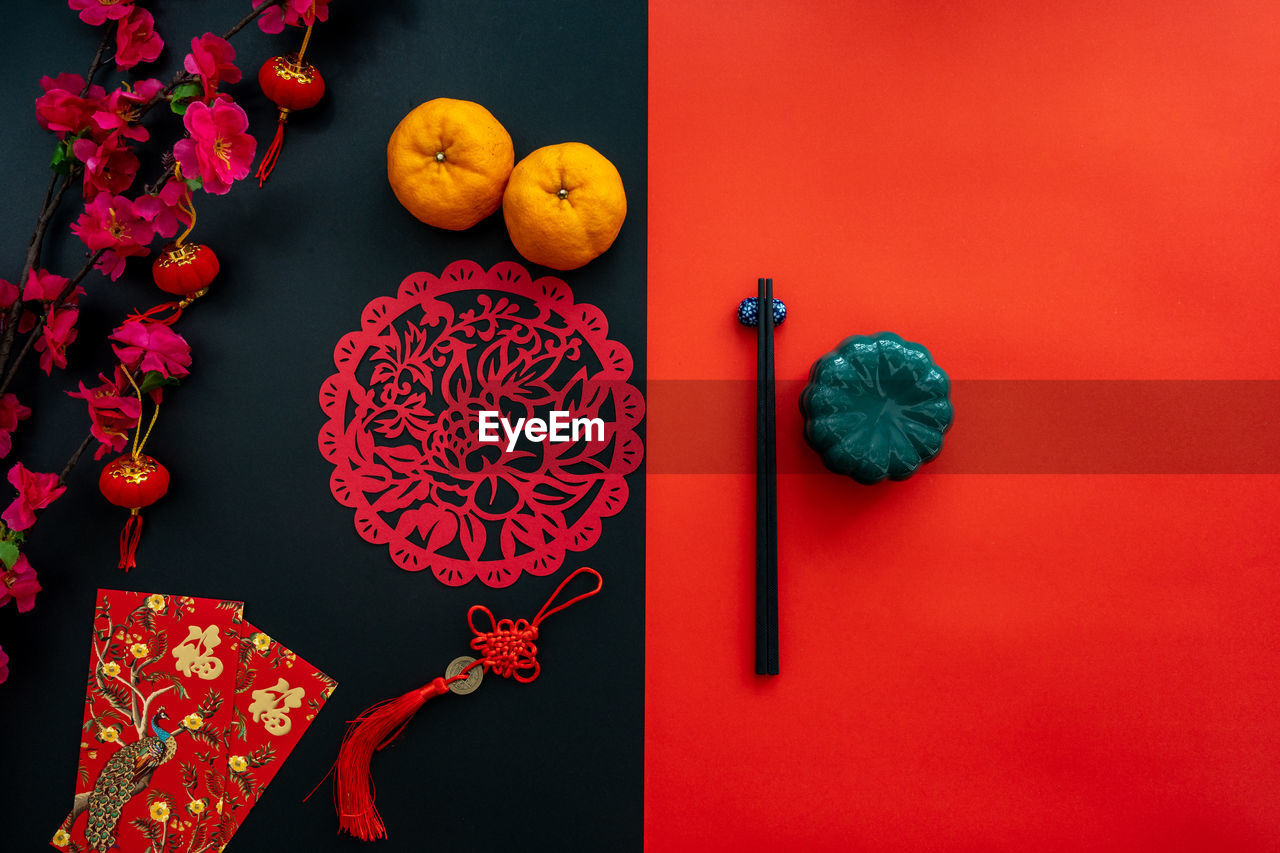 Chinese lunar new year decoration over red and black background. flat lay dinning table concept.