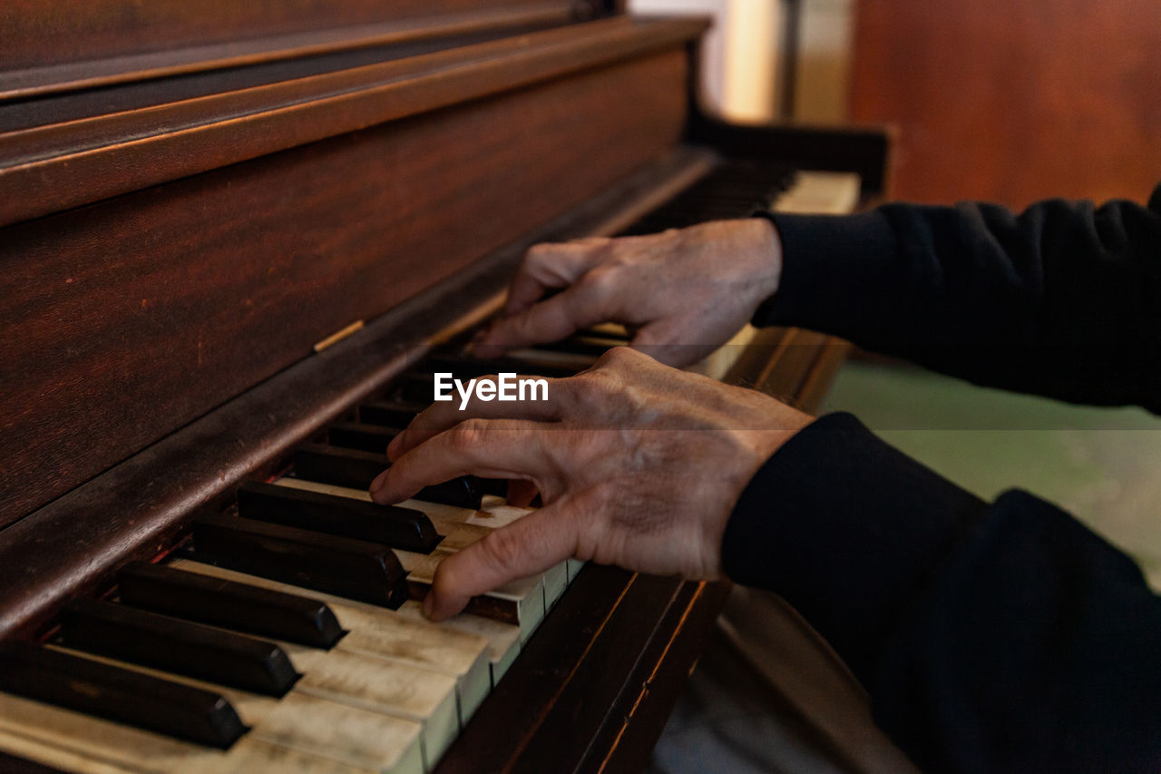 Midsection of man playing piano