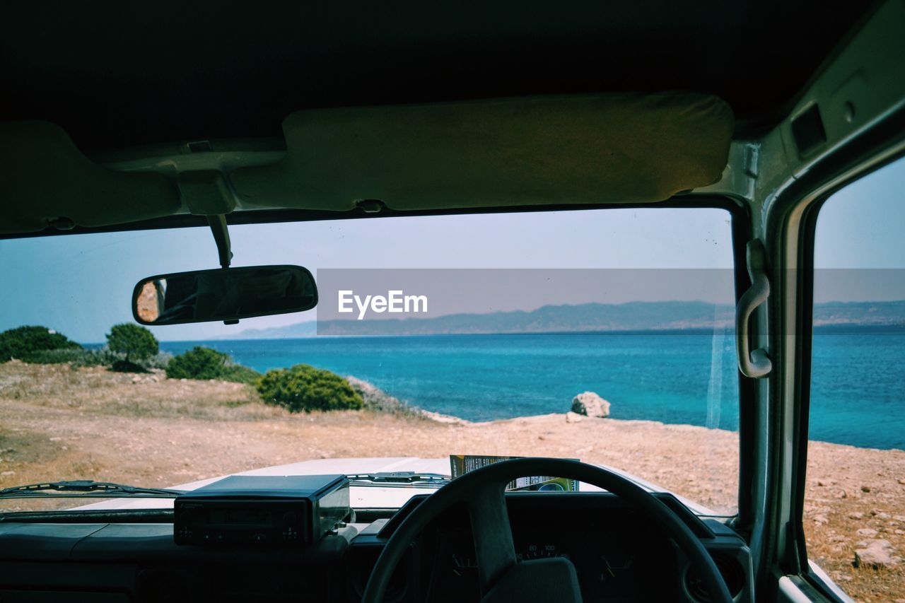 Scenic view of sea seen through off-road vehicle windshield