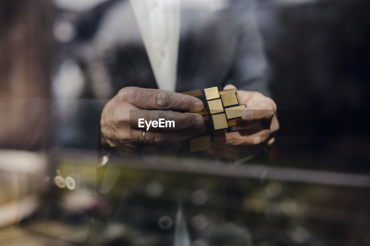 Senior businessman putting together puzzle cube