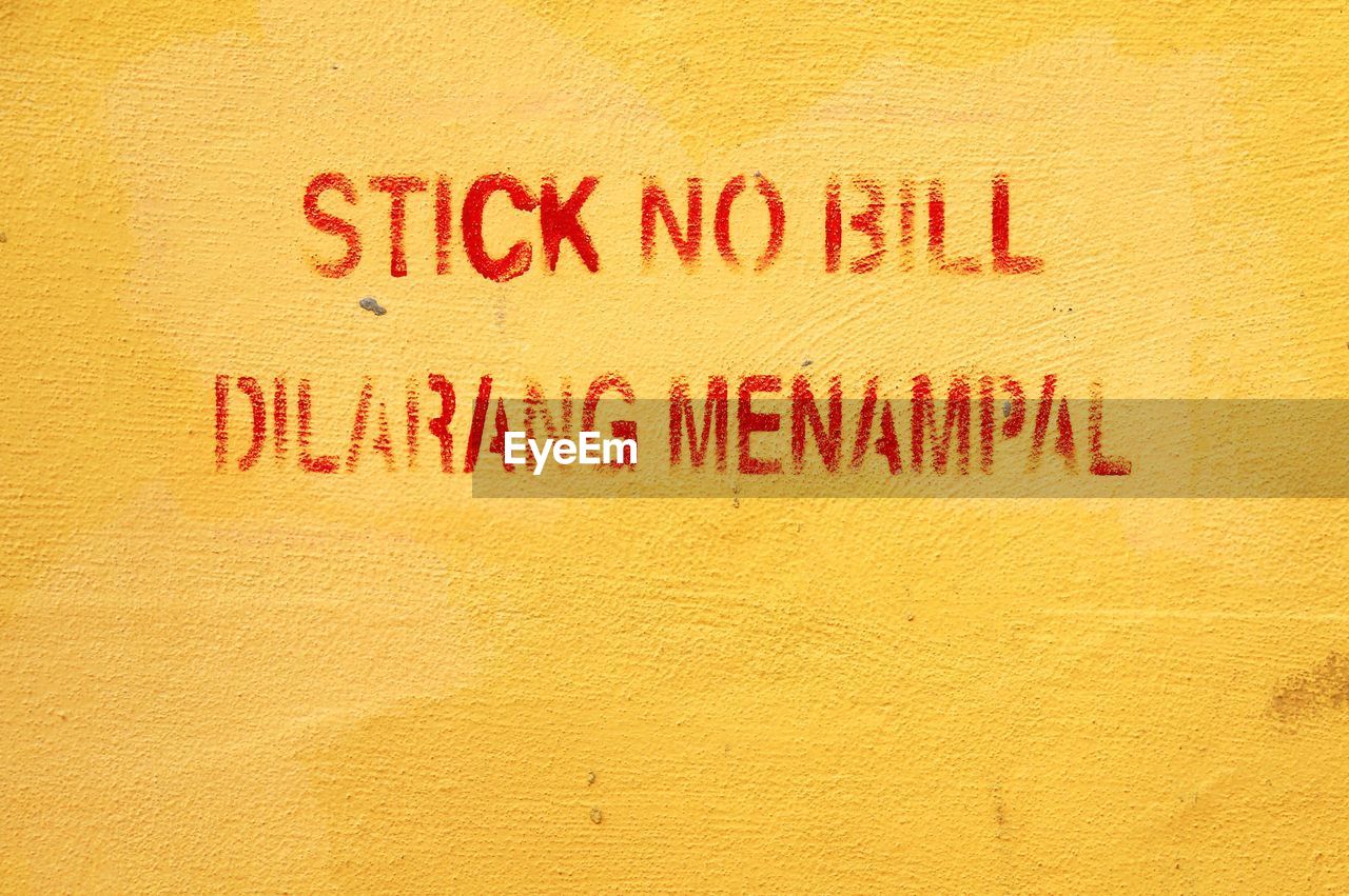 Text on yellow textured wall