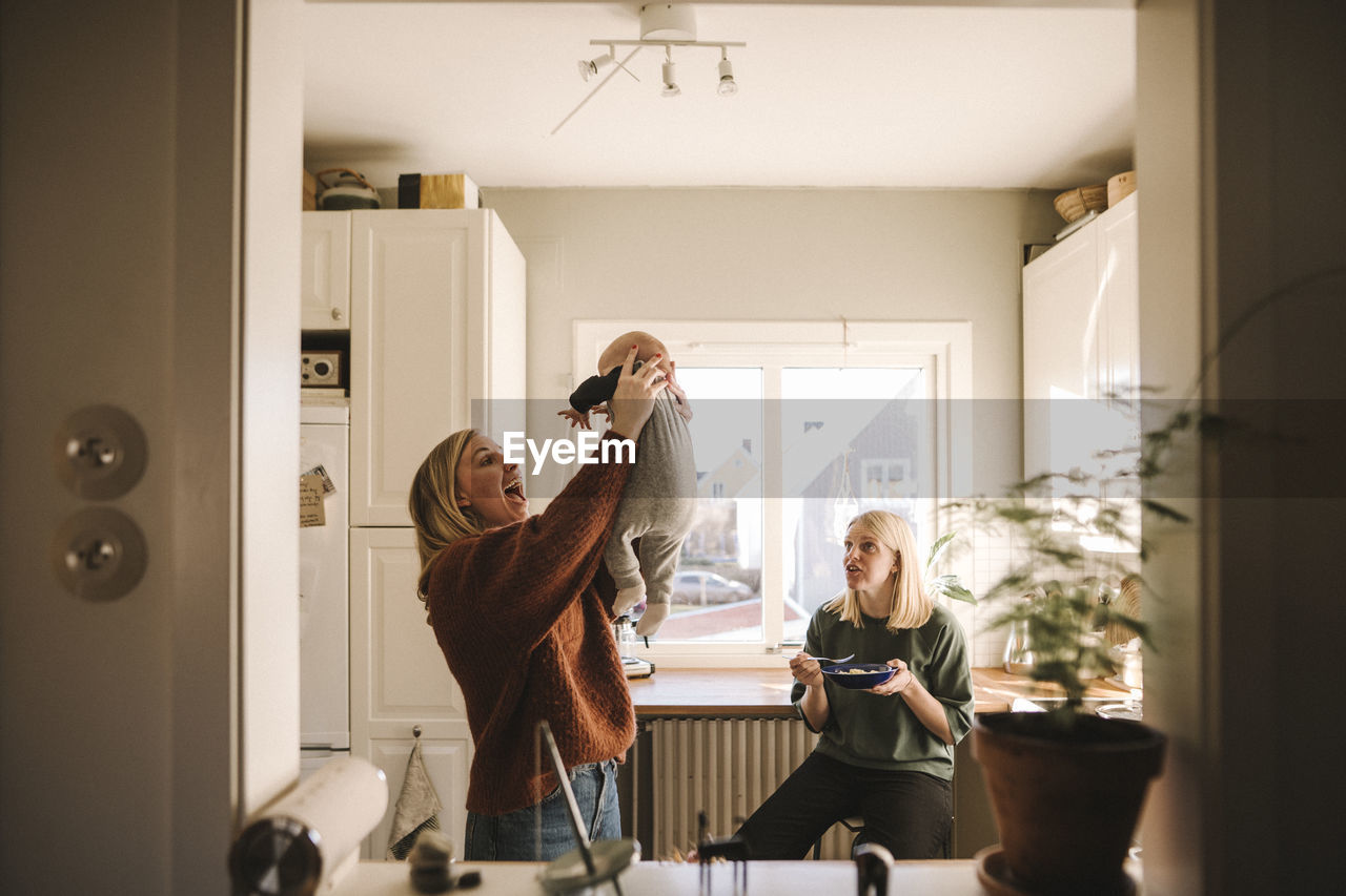 Mothers playing with newborn baby at home